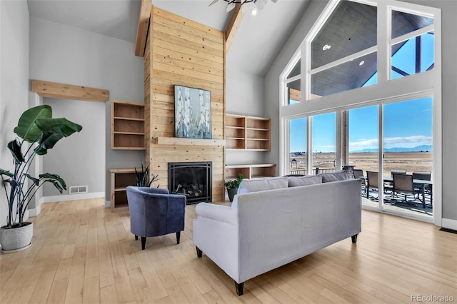 7668 Buckskin Ranch Vw, Peyton, CO 80831 - living area featuring light wood-type flooring, baseboards, visible vents, and high vaulted ceiling