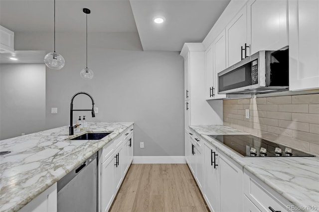 7668 Buckskin Ranch Vw, Peyton, CO 80831 - kitchen featuring tasteful backsplash, a sink, stainless steel appliances, light wood finished floors, and white cabinetry