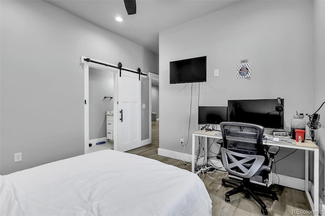 7668 Buckskin Ranch Vw, Peyton, CO 80831 - bedroom with a barn door, wood finished floors, ceiling fan, baseboards, and recessed lighting