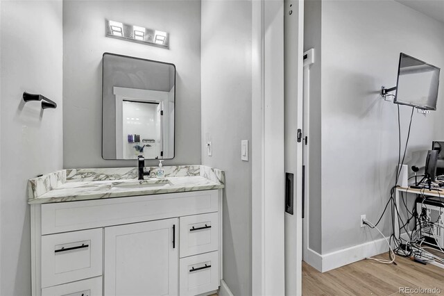 7668 Buckskin Ranch Vw, Peyton, CO 80831 - bathroom featuring baseboards, vanity, and wood finished floors