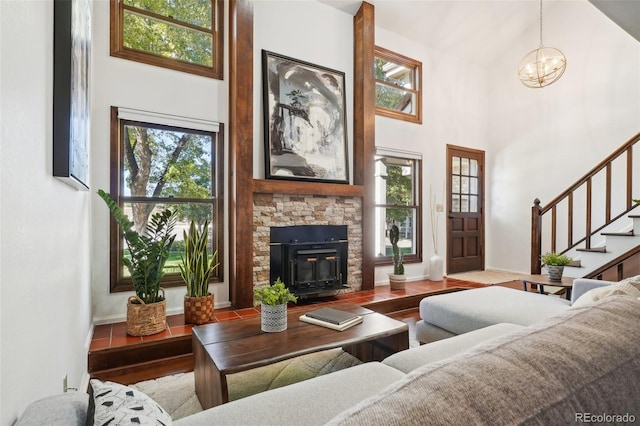 living room with a towering ceiling, light hardwood / wood-style flooring, and a chandelier