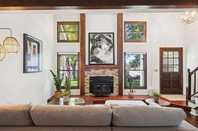 living room with a wood stove, a chandelier, and hardwood / wood-style flooring