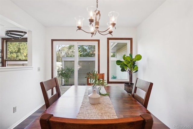 dining room featuring plenty of natural light, dark hardwood / wood-style flooring, and a chandelier