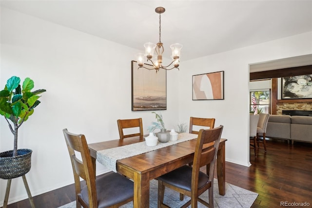 dining room with a fireplace, dark hardwood / wood-style floors, and a notable chandelier