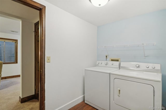 clothes washing area with light carpet and washer and clothes dryer