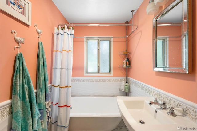 5584 S Datura St, Littleton, CO 80120 - full bath featuring a bathtub, wainscoting, and tile walls