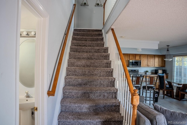 staircase featuring a textured ceiling