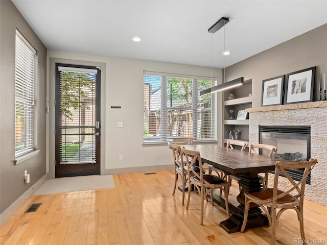 2741 Java Ct, Denver, CO 80211 - dining room featuring light wood-type flooring, a stone fireplace, baseboards, built in features, and recessed lighting