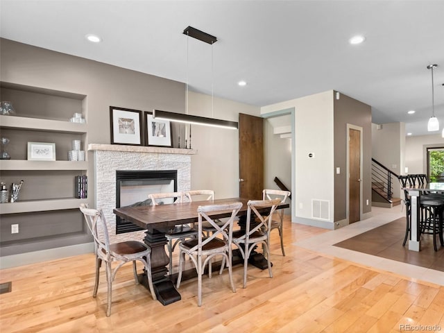 2741 Java Ct, Denver, CO 80211 - dining area with light wood-style floors, a stone fireplace, stairway, baseboards, and recessed lighting