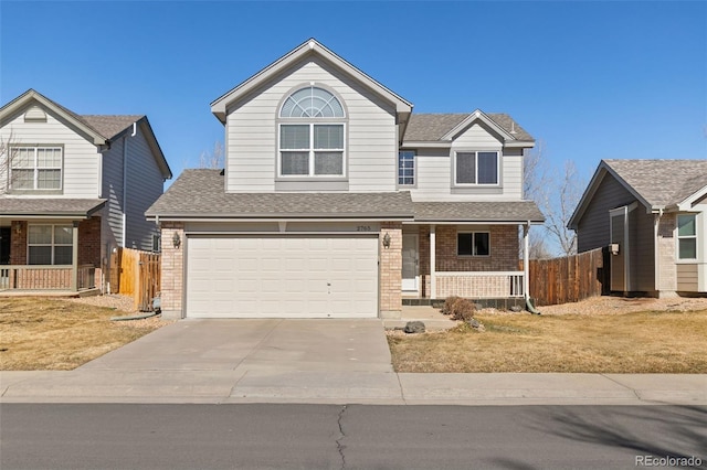 traditional home featuring driveway, a porch, fence, and brick siding