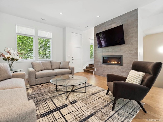 living room with a fireplace and light wood-type flooring