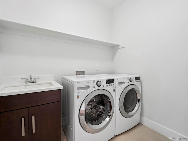 laundry area with cabinets, independent washer and dryer, and sink