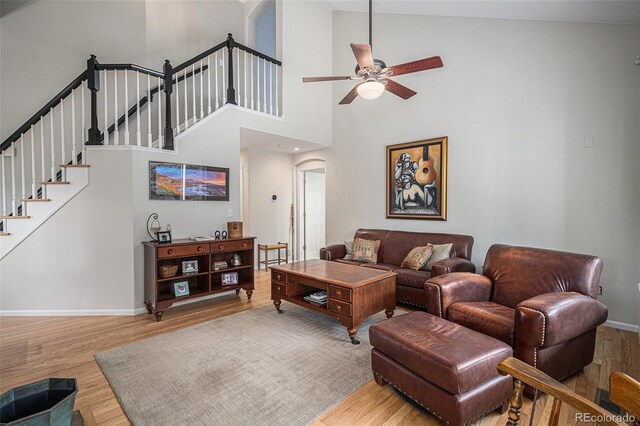 7696 S Hudson Way, Centennial, CO 80122 - living room featuring arched walkways, wood finished floors, ceiling fan, baseboards, and high vaulted ceiling
