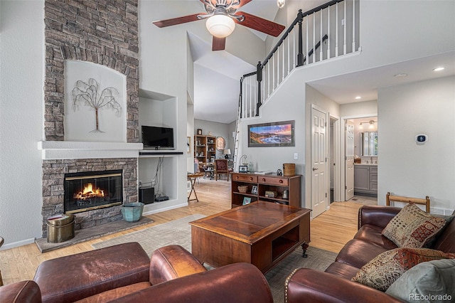 7696 S Hudson Way, Centennial, CO 80122 - living area featuring a ceiling fan, a towering ceiling, wood finished floors, a fireplace, and baseboards