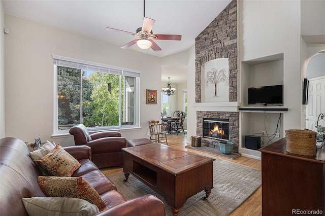 7696 S Hudson Way, Centennial, CO 80122 - living area featuring ceiling fan, wood finished floors, lofted ceiling, a fireplace, and a chandelier