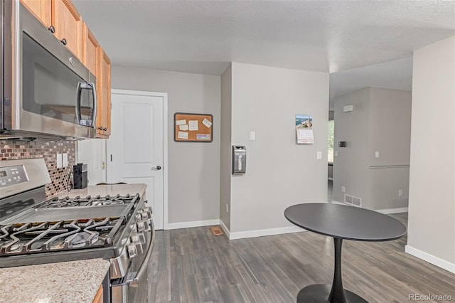 1371 W 133rd Way, Denver, CO 80234 - kitchen featuring appliances with stainless steel finishes, dark wood-style flooring, and backsplash