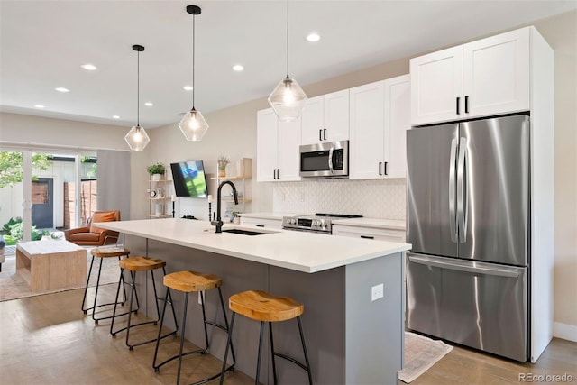 3103 S Cherokee St, Englewood, CO 80110 - kitchen with stainless steel appliances, wood finished floors, decorative backsplash, a breakfast bar, and recessed lighting
