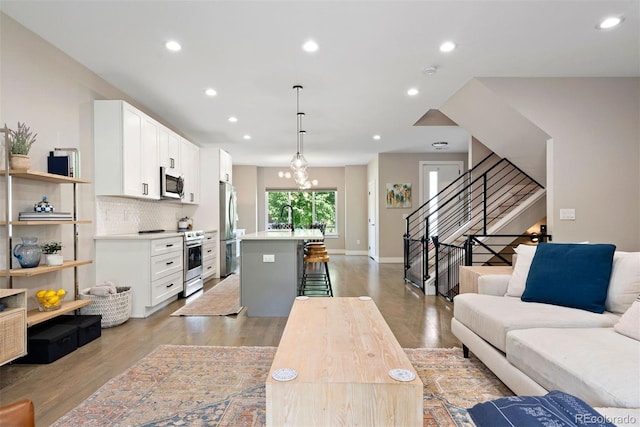 3103 S Cherokee St, Englewood, CO 80110 - living area featuring recessed lighting, light wood-style flooring, and stairs