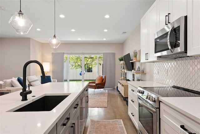 3103 S Cherokee St, Englewood, CO 80110 - kitchen with appliances with stainless steel finishes, open floor plan, recessed lighting, light countertops, and backsplash