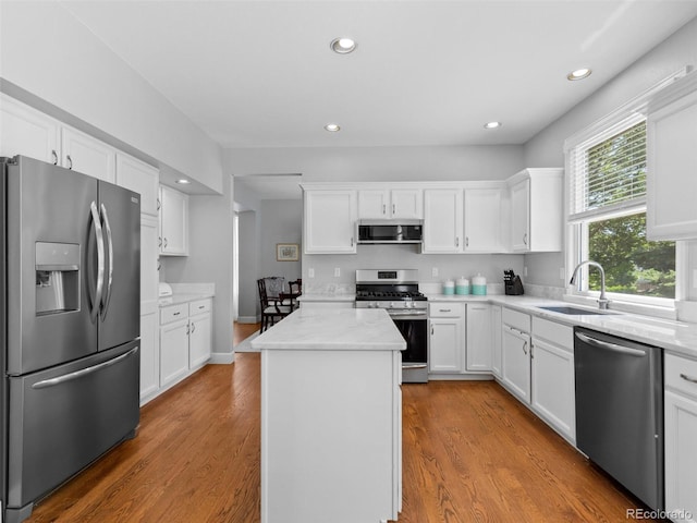 16362 Oakmoor Pl, Parker, CO 80134 - kitchen with appliances with stainless steel finishes, a center island, white cabinets, wood finished floors, and recessed lighting
