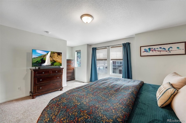 carpeted bedroom with baseboards and a textured ceiling