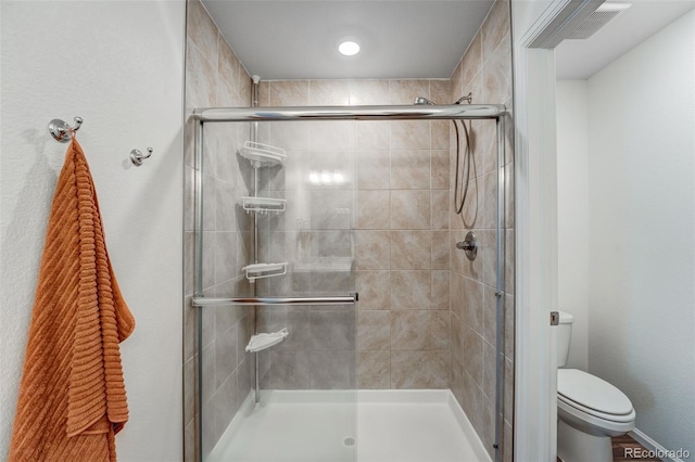 full bathroom featuring a stall shower and toilet