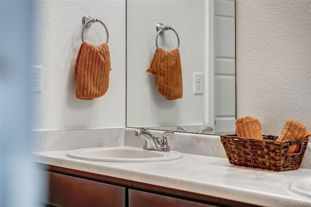 bathroom with vanity and a textured wall