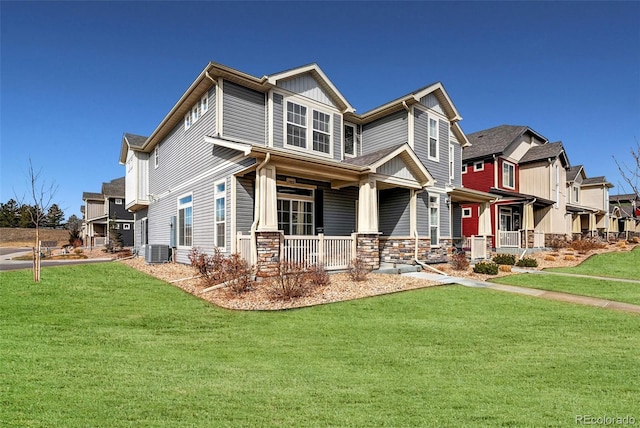 craftsman-style home with central air condition unit, covered porch, a front lawn, and stone siding