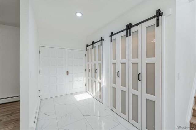 corridor with light hardwood / wood-style floors and a barn door