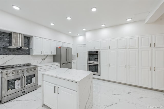 kitchen featuring light tile patterned flooring, wall chimney exhaust hood, white cabinets, and premium appliances