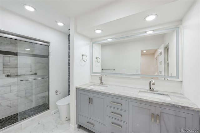 bathroom with tile patterned flooring, a shower with door, vanity, and toilet