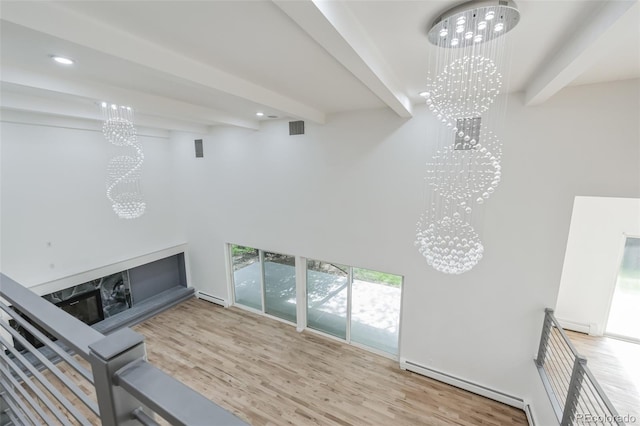 living room with beam ceiling, wood-type flooring, baseboard heating, and an inviting chandelier