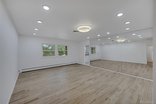 interior space with light hardwood / wood-style floors and a baseboard heating unit