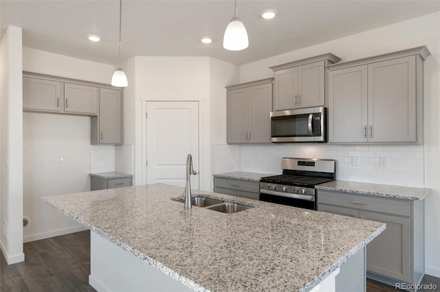 6721 Raven Ridge Ter, Colorado Springs, CO 80925 - kitchen with stainless steel appliances, gray cabinetry, a sink, dark wood finished floors, and light stone counters