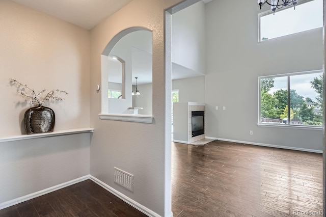 11029 Grouse Ct, Parker, CO 80134 - hall featuring wood finished floors, arched walkways, and a chandelier