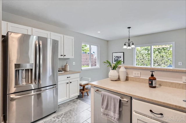 11029 Grouse Ct, Parker, CO 80134 - kitchen with appliances with stainless steel finishes, white cabinets, a chandelier, decorative light fixtures, and light marble finish flooring