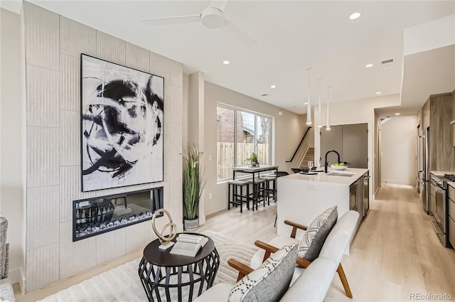 2323 S High St, Denver, CO 80210 - living room with light wood finished floors, a ceiling fan, recessed lighting, and stairway