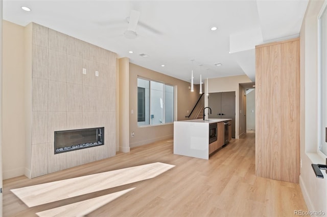 2323 S High St, Denver, CO 80210 - unfurnished living room with light wood-style floors, a fireplace, recessed lighting, and a ceiling fan