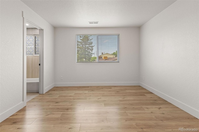 18396 E Mexico Pl, Aurora, CO 80017 - empty room with light wood-style flooring, baseboards, and a textured ceiling