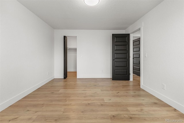18396 E Mexico Pl, Aurora, CO 80017 - unfurnished bedroom featuring light wood-style flooring, a spacious closet, baseboards, and a closet