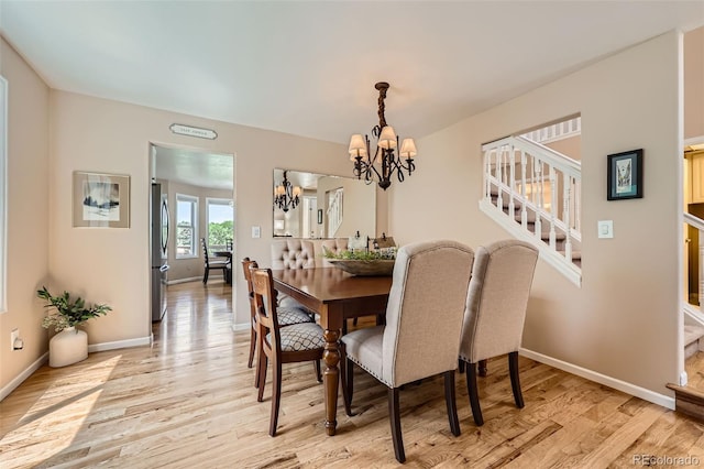 9733 Quay Loop, Broomfield, CO 80021 - dining room with a chandelier, light wood-style floors, and stairway