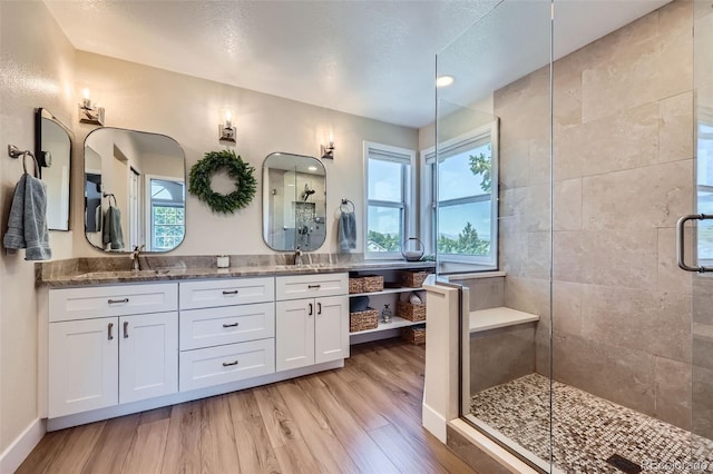 9733 Quay Loop, Broomfield, CO 80021 - bathroom with tiled shower, wood finished floors, and double vanity