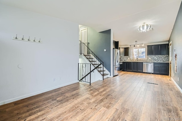 unfurnished living room featuring light hardwood / wood-style floors and sink