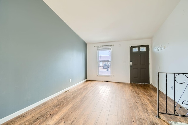 entrance foyer featuring light hardwood / wood-style floors and vaulted ceiling