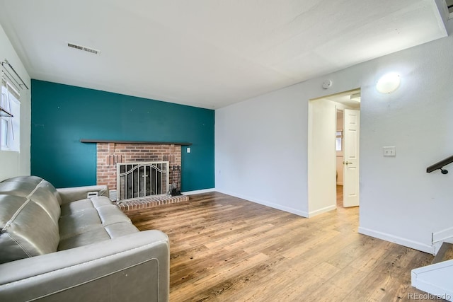 living room featuring hardwood / wood-style floors and a brick fireplace