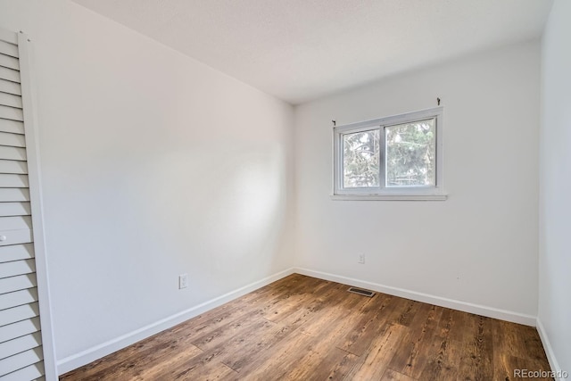 spare room with dark hardwood / wood-style floors