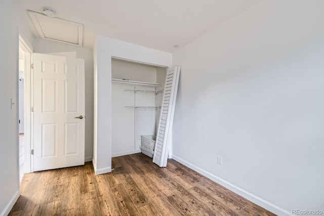 unfurnished bedroom featuring dark wood-type flooring and a closet