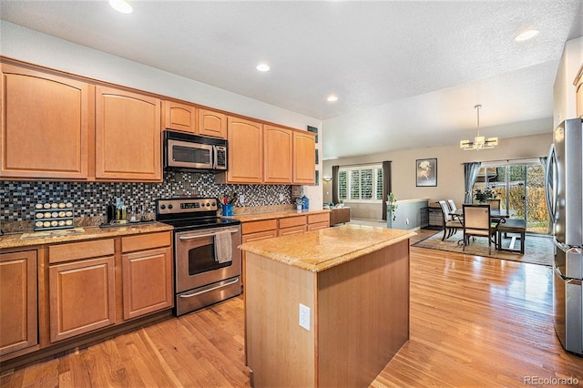 1155 S Balsam St, Lakewood, CO 80232 - kitchen featuring backsplash, a kitchen island, appliances with stainless steel finishes, light stone countertops, and light wood-style floors