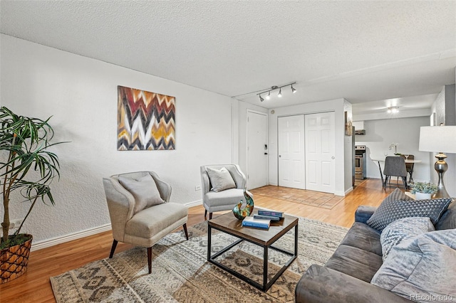 3047 W 47th Ave Unit 112, Denver, CO 80211 - living area featuring wood finished floors, baseboards, and a textured ceiling