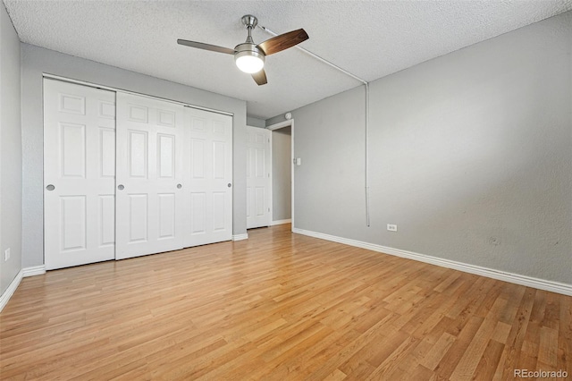 3047 W 47th Ave Unit 112, Denver, CO 80211 - unfurnished bedroom featuring light wood finished floors, baseboards, a closet, a ceiling fan, and a textured ceiling